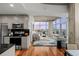 Open-concept living room and kitchen with stainless steel appliances, hardwood floors, and concrete accents at 1700 Bassett St # 1612, Denver, CO 80202