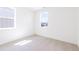 Bright bedroom with white walls, carpet, and two windows at 245 Washington St, Erie, CO 80516