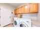 Laundry room features a washer, dryer, upper cabinets, and a utility sink at 19755 W 57Th Cir, Golden, CO 80403