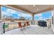 Spacious covered patio with outdoor seating, a grill, and a view of the surrounding neighborhood at 19755 W 57Th Cir, Golden, CO 80403