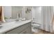 Stylish bathroom featuring a single vanity, large mirror, white subway tile shower, and wood look flooring at 5108 N Quatar St, Aurora, CO 80019