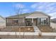 Charming single-story home featuring stone accents, a covered porch, and manicured front yard at 5108 N Quatar St, Aurora, CO 80019