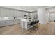 Spacious kitchen featuring island with seating, modern lighting and stainless steel appliances at 5108 N Quatar St, Aurora, CO 80019