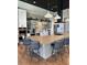 Modern kitchen boasts stainless steel appliances, a large island with seating, and stylish open shelving at 5108 N Quatar St, Aurora, CO 80019