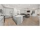 Open-concept kitchen with a large island, stainless appliances, and seamless flow to living space at 5108 N Quatar St, Aurora, CO 80019