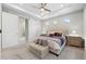 Elegant main bedroom suite showcasing a tray ceiling, stylish furnishings, and a barn door entry to the ensuite bathroom at 5108 N Quatar St, Aurora, CO 80019