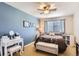 Bedroom features a decorative blue accent wall, ceiling fan, and a window for natural light at 11332 E 111Th Ave, Commerce City, CO 80640