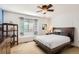 Bedroom features a modern bed frame, ceiling fan, and a bright window for natural light at 11332 E 111Th Ave, Commerce City, CO 80640