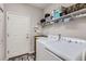 Bright laundry room features a washer, dryer, utility sink, and overhead shelving at 11332 E 111Th Ave, Commerce City, CO 80640