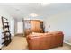 Spacious living room with comfortable leather seating, entertainment center, and neutral carpeting at 11332 E 111Th Ave, Commerce City, CO 80640