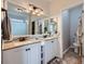 Well-lit bathroom featuring double sinks, granite countertops, and neutral tile backsplash at 5490 Suffolk Ave, Castle Rock, CO 80104