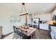 Bright kitchen and dining area featuring hardwood floors, modern lighting, and a sliding door to the backyard at 5490 Suffolk Ave, Castle Rock, CO 80104