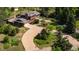 An aerial view of a well-maintained home with lush landscaping, a circular driveway, and mature trees providing privacy at 8836 Marathon Rd, Longmont, CO 80503