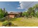 Expansive backyard features mature trees, lush lawn, garden area, and patio seating perfect for entertaining guests at 8836 Marathon Rd, Longmont, CO 80503