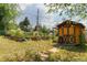 Backyard features raised garden beds, storage shed, and a well-maintained lawn for outdoor enjoyment and gardening at 8836 Marathon Rd, Longmont, CO 80503