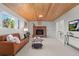 Finished basement with a cozy fireplace, wood-paneled ceiling, and comfortable seating area at 8836 Marathon Rd, Longmont, CO 80503