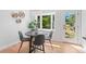 Cozy dining area bathed in sunlight with modern furnishings and serene views of the outdoors through a large bay window at 8836 Marathon Rd, Longmont, CO 80503