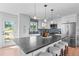 Modern kitchen island with stools and sleek countertops, with stainless steel appliances creating the perfect gathering space at 8836 Marathon Rd, Longmont, CO 80503