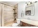 Bathroom with a shower/tub combo, unique wall tile, and ample lighting at 9731 W Polk Dr, Littleton, CO 80123