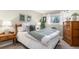 Bright bedroom with hardwood floors, a large window, a wooden dresser, and neutral-tone decor at 9731 W Polk Dr, Littleton, CO 80123