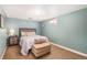 Cozy bedroom features light blue walls, warm carpet, and a comfortable queen-size bed with decorative pillows at 9731 W Polk Dr, Littleton, CO 80123