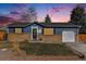 Charming single-story home with a well-maintained lawn and an attached garage, all under a dramatic sunset sky at 9731 W Polk Dr, Littleton, CO 80123