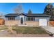 Charming single-story home featuring a brick facade, blue siding, and a well-maintained front yard at 9731 W Polk Dr, Littleton, CO 80123