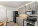 Galley kitchen with stainless steel appliances, neutral colors, and lots of storage at 9731 W Polk Dr, Littleton, CO 80123