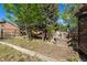 Fenced backyard featuring a custom play structure with slide, climbing area, and wooden boat at 308 Oswego St, Aurora, CO 80010