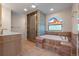 Bright bathroom featuring a tub with tile surround, glass block window, and walk-in shower at 308 Oswego St, Aurora, CO 80010