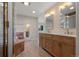 Bathroom with double sink vanity, decorative mirrors, and glass block shower with tub at 308 Oswego St, Aurora, CO 80010