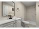Updated bathroom with white vanity, decorative mirror, and tiled walk-in shower at 308 Oswego St, Aurora, CO 80010