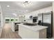 Modern kitchen featuring stainless steel appliances, a gas cooktop island, and bright white cabinetry at 308 Oswego St, Aurora, CO 80010