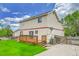 Spacious backyard featuring a wooden deck and well-maintained lawn with a cloudy sky above at 5023 Goshawk Ct, Brighton, CO 80601