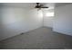 A bright bedroom features neutral walls, carpet, and a ceiling fan at 5023 Goshawk Ct, Brighton, CO 80601