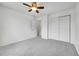 Bright bedroom with ceiling fan, gray carpet, and closet at 5023 Goshawk Ct, Brighton, CO 80601