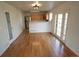 Open concept dining room with hardwood floors, breakfast bar, and access to the kitchen at 5023 Goshawk Ct, Brighton, CO 80601