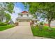 Inviting two-story home with a well-kept lawn and driveway leading to an attached two-car garage at 5023 Goshawk Ct, Brighton, CO 80601