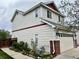 Side view of home with beige siding, showcasing the landscaped yard and the attached garage at 5023 Goshawk Ct, Brighton, CO 80601