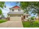 Charming two-story home with a two-car garage, red accents, and a well-manicured front yard at 5023 Goshawk Ct, Brighton, CO 80601