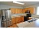 Well-lit kitchen with stainless steel appliances, oak cabinets, and a double sink at 5023 Goshawk Ct, Brighton, CO 80601