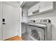 Convenient laundry room with modern washer and dryer, storage cabinets, and organized space at 5023 Goshawk Ct, Brighton, CO 80601