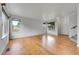 Open-concept living room with gleaming hardwood floors and large windows at 5023 Goshawk Ct, Brighton, CO 80601