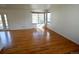 Bright living room features hardwood floors and natural light from the large windows and door at 5023 Goshawk Ct, Brighton, CO 80601