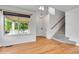 Sun-filled living room with hardwood floors, large window, and staircase leading upstairs at 5023 Goshawk Ct, Brighton, CO 80601