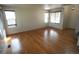 Spacious living room with hardwood floors, three windows, and a neutral color palette at 5023 Goshawk Ct, Brighton, CO 80601