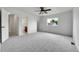 Spacious main bedroom featuring a ceiling fan, neutral carpet, a window and access to a full bathroom at 5023 Goshawk Ct, Brighton, CO 80601