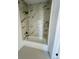 Modern bathroom with marbled tile, a shower head, and a sleek bathtub at 17362 County Road 29, Platteville, CO 80651