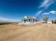 Exterior view showcasing the house with large yard, metal roof and white siding at 17362 County Road 29, Platteville, CO 80651