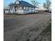 Charming white farmhouse with a metal roof and a spacious porch perfect for relaxing and enjoying the outdoors at 17362 County Road 29, Platteville, CO 80651